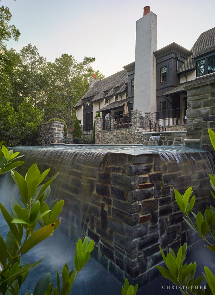 French Normandy Infinity Pool with Stone Wall and Built-In Hot Tub